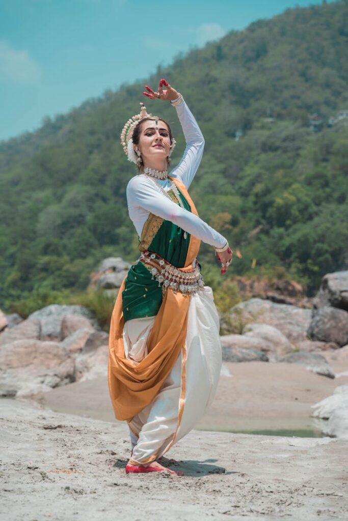 Capture of a female Odissi dancer performing gracefully in traditional attire outdoors in Puri, India.